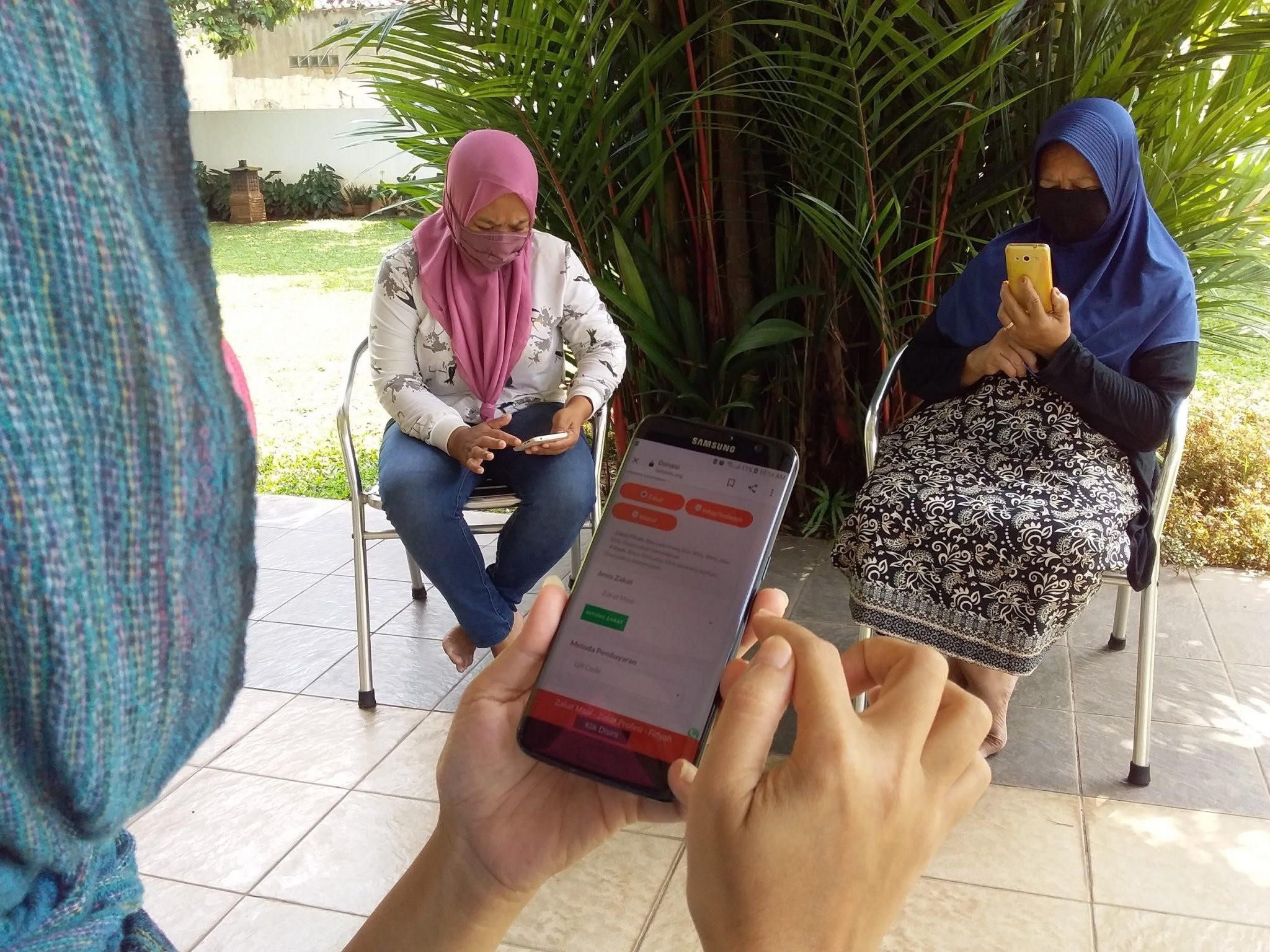 Figure 4: How to pay zakat? Ladies at Cidokom Bogor try to open an online zakat service. Photo © Amelia Fauzia

