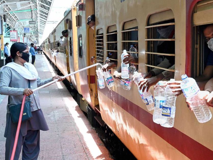 Figure 5. Amid coronavirus lockdown, heat wave has intensified in several states across north India. A railway employee refills water bottles of migrants sitting in a train to reach their native places, during the ongoing COVID-19 lockdown, in Jabalpur.
Image Credit: PTI